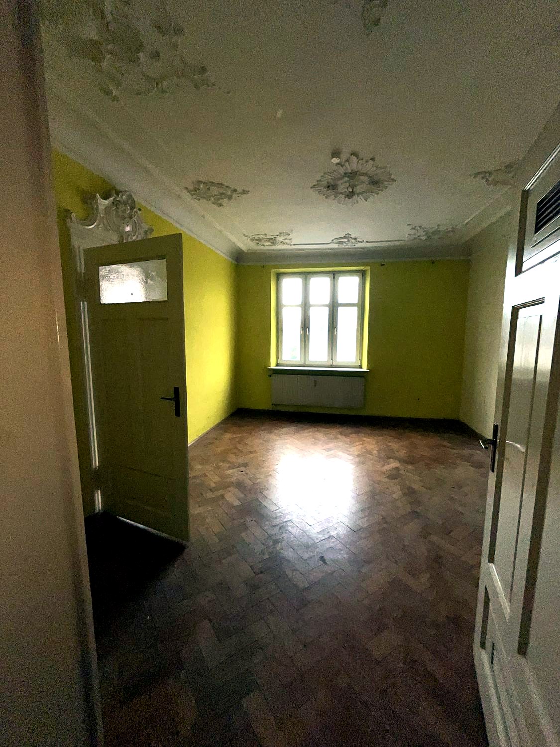 Dasselbe Zimmer nach der Räumung — Parkett und Stuck wieder frei